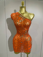 Orange beaded dress on a mannequin against a plain background